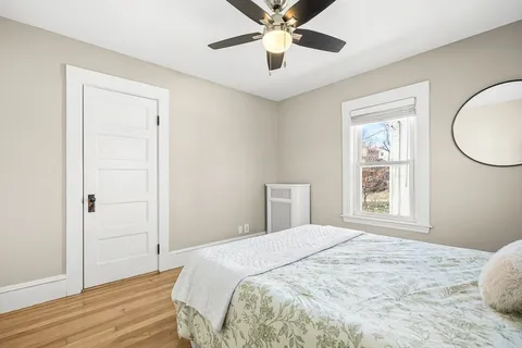 a bedroom with a large bed and wooden floor