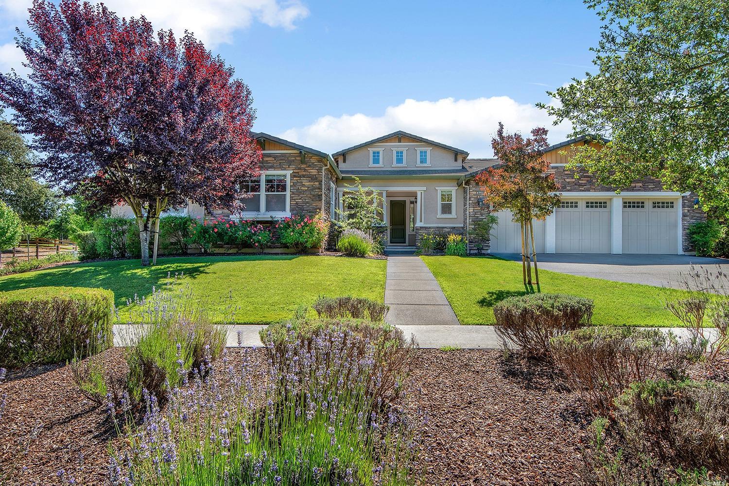 a view of a house with a big yard and large trees