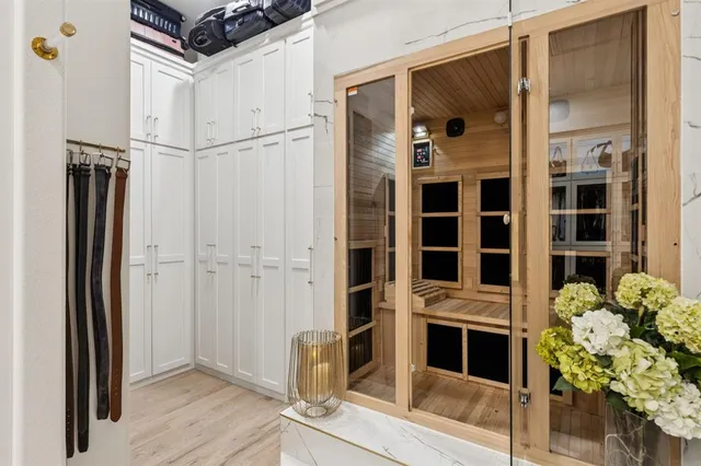 a white bath tub sitting next to a white wall and a painting on the wall