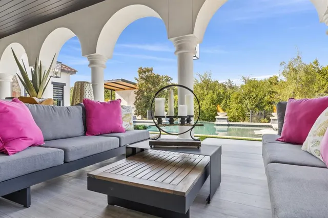 a view of a patio with table and chairs with wooden floor and fence