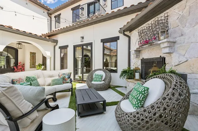 a view of a building with couches potted plants and a table