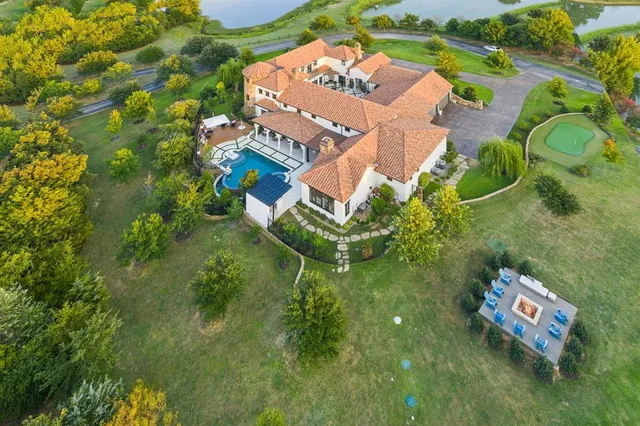 an aerial view of residential houses with outdoor space and trees