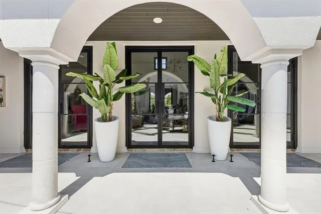 a hallway with table and potted plants