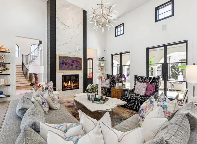 a living room with furniture large window and fireplace