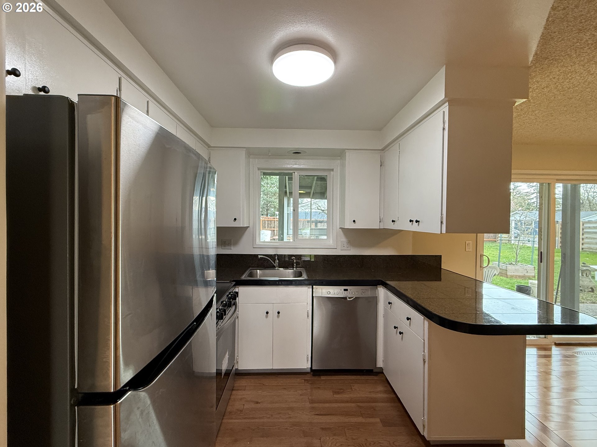 5270 Southwest 182nd Avenue Beaverton, OR 97078 - Photo 12 of 35 a kitchen with granite countertop a sink a counter space appliances and cabinets