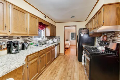 a kitchen with stainless steel appliances granite countertop a stove a sink and a refrigerator