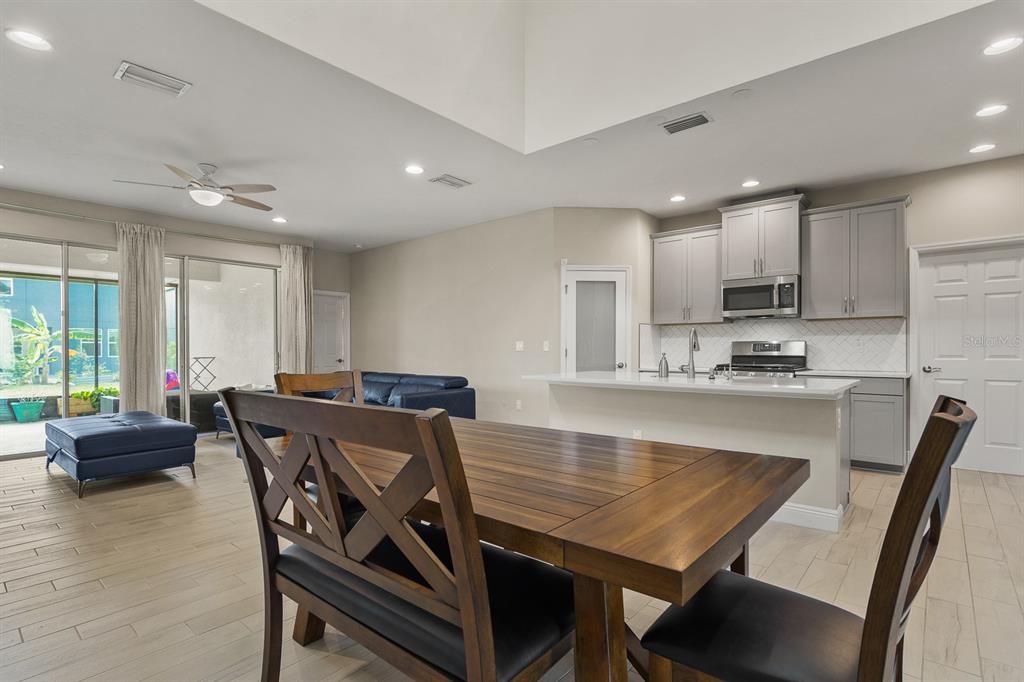 17880 Moon Rise Pass Land O Lakes, FL 34638 - Photo 13 of 43 a view of kitchen with granite countertop stove top oven dining table and chairs