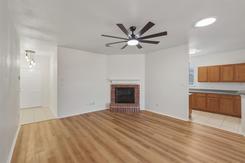 13509 Ponderosa Ranch Road Fort Worth, TX 76262 - Photo 13 of 33 Brick fireplace, cool ceiling fan, and open concept.