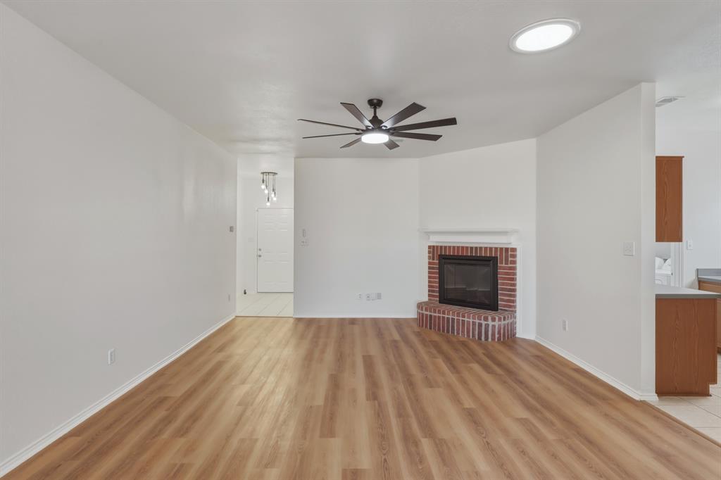 13509 Ponderosa Ranch Road Fort Worth, TX 76262 - Photo 15 of 33 Brick fireplace in living room with new laminate floors.