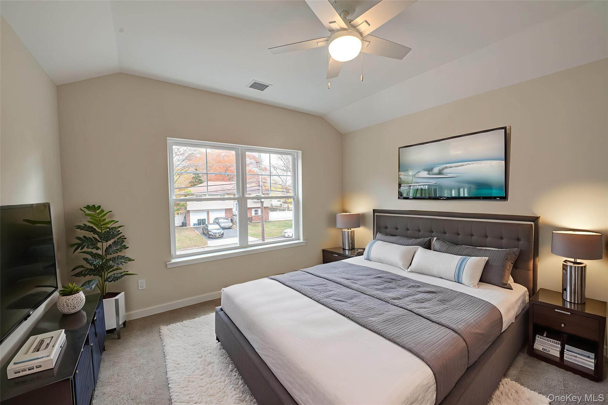 370 Canal Road Port Jefferson Station, NY 11776 - Photo 10 of 16 a bedroom with a large bed and a chandelier