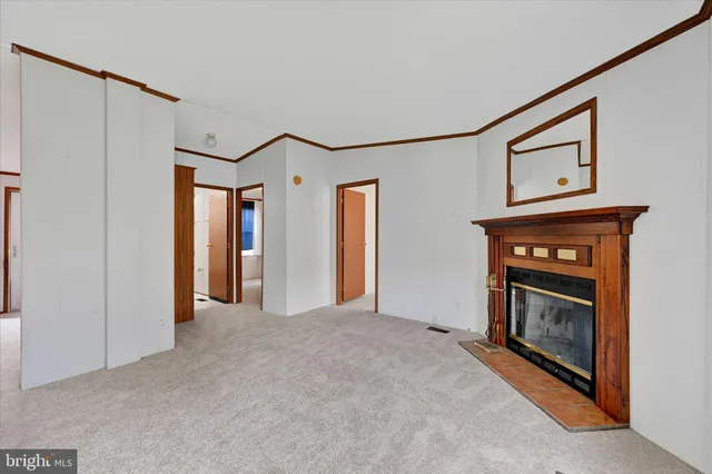 a view of an empty room with a fireplace and a window