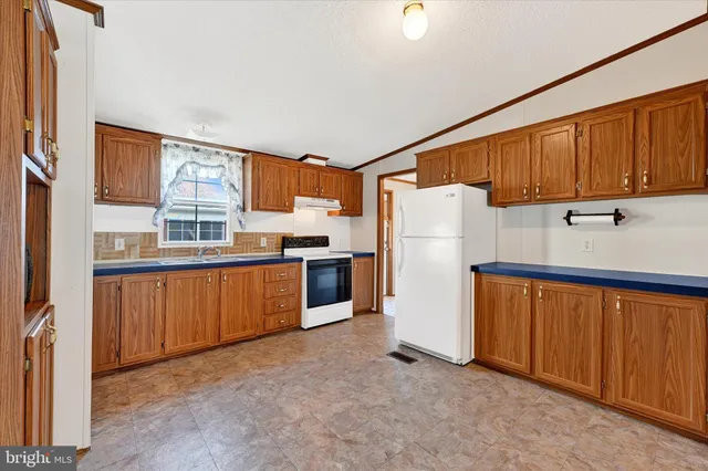 a kitchen with refrigerator and cabinets