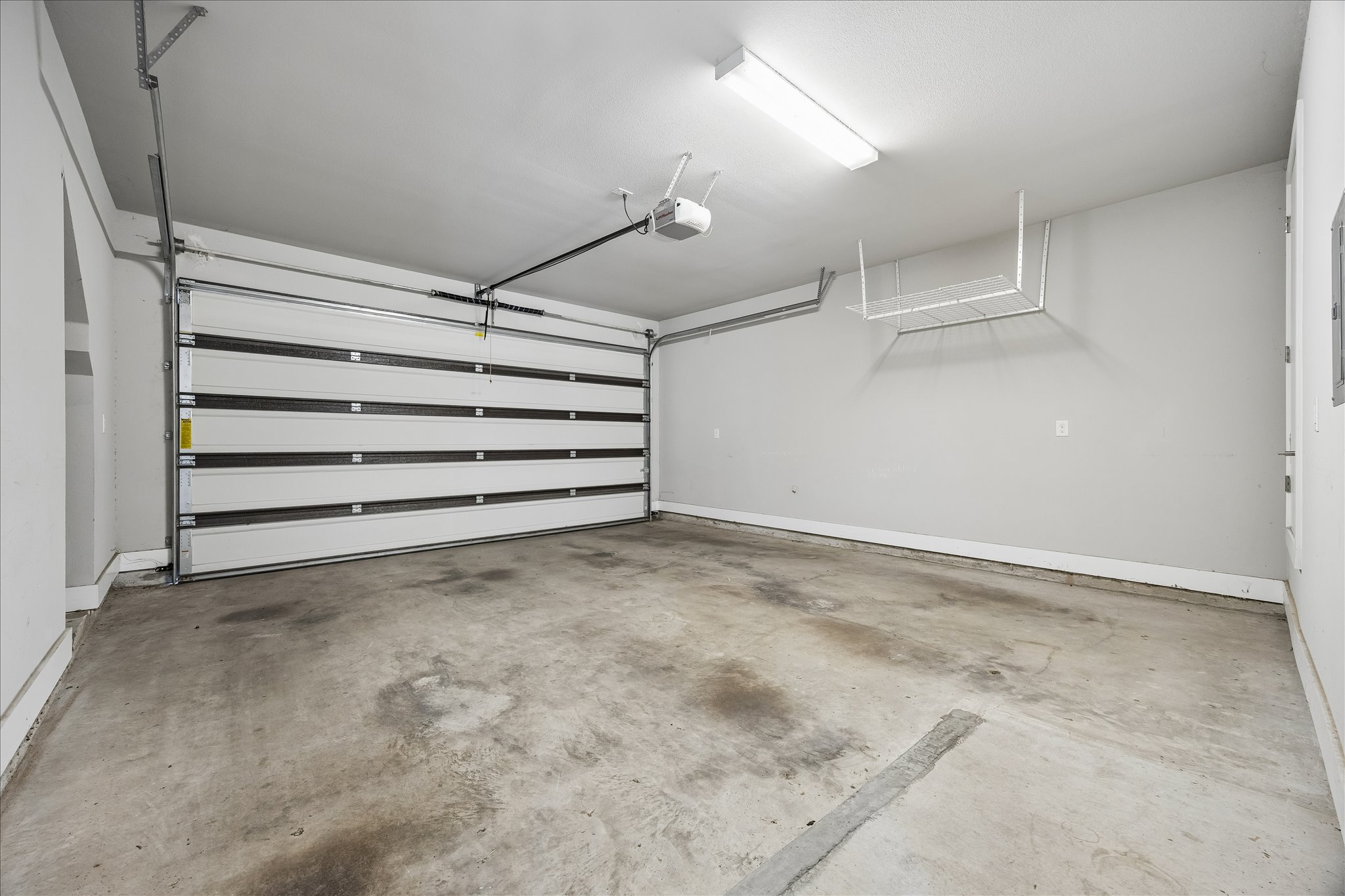 5006 Pecan Springs Road, Unit 6 Austin, TX 78723 - Photo 26 of 30 A spacious, pristine garage offers ample room for vehicles and organized storage with overhead shelving.