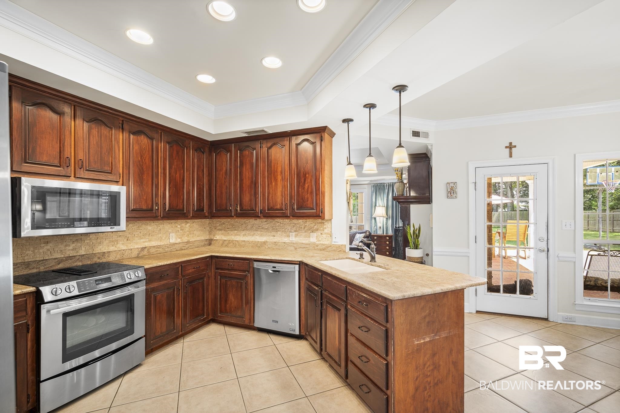 402 Potters Mills Road Daphne, AL 36526 - Photo 11 of 45 Kitchen featuring stainless steel appliances, a peninsula, a sink, tasteful backsplash, and light tile patterned floors