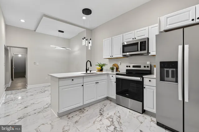 a kitchen with stainless steel appliances white cabinets a sink and a stove