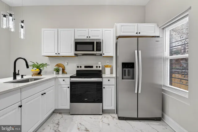a kitchen with stainless steel appliances a refrigerator sink and microwave