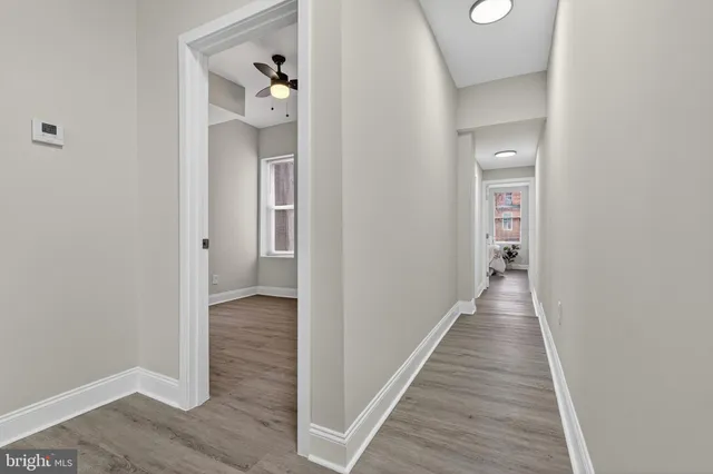 a view of a hallway with wooden floor and staircase