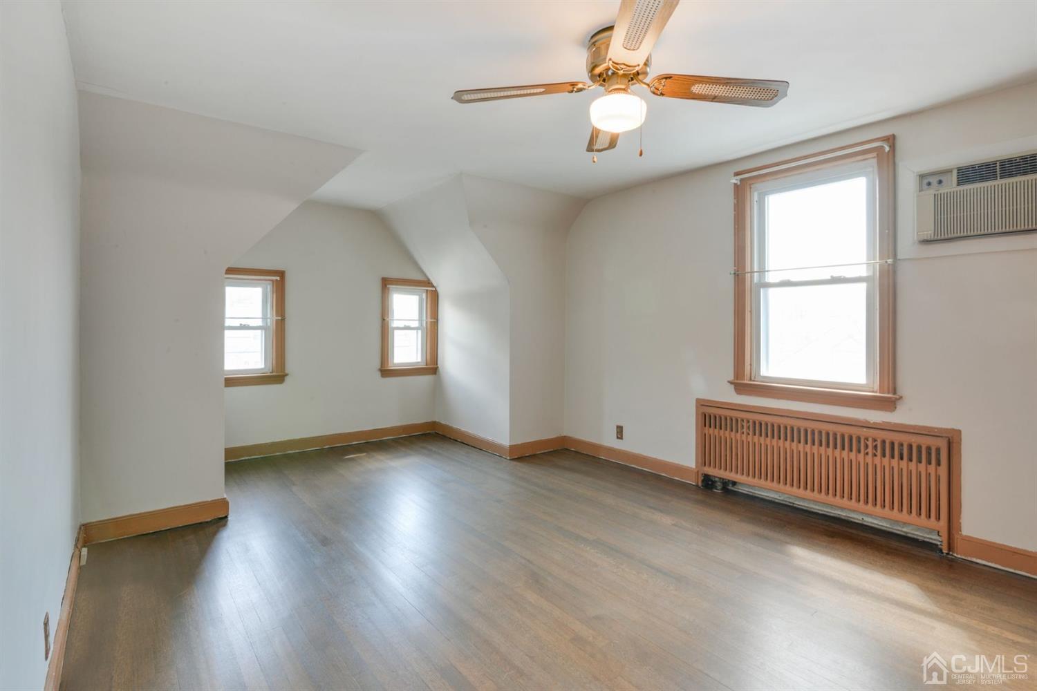120 Harvard Road Linden, NJ 07036 - Photo 14 of 19 an empty room with wooden floor chandelier fan and windows
