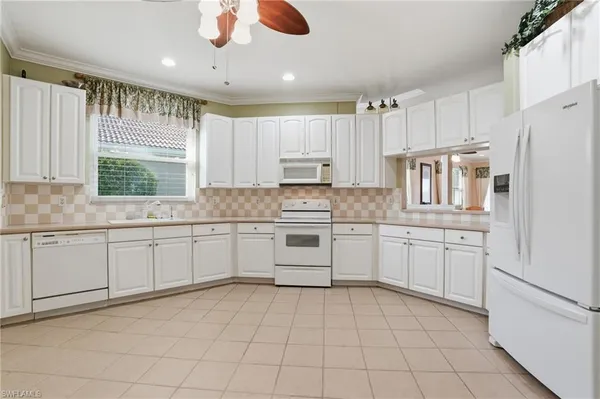 a kitchen with granite countertop cabinets stainless steel appliances a sink and a window