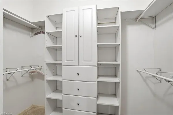 a view of walk in closet with empty racks