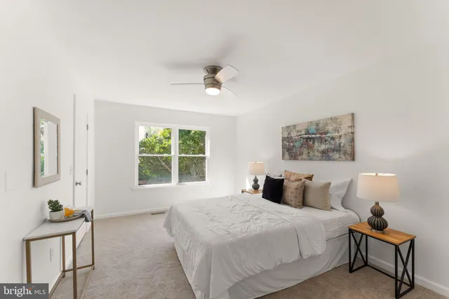 a bedroom with a bed and a lamp on dresser