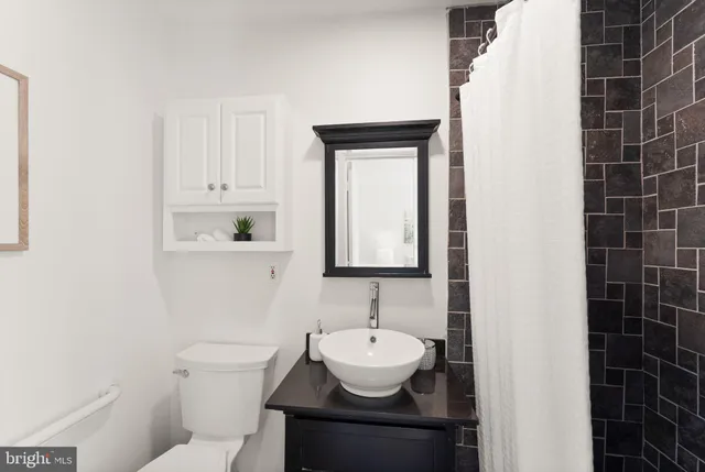 a bathroom with a sink a toilet and mirror