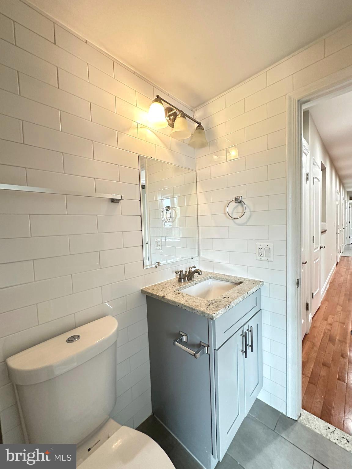 1626 R Street Southeast Washington, DC 20020 - Photo 10 of 17 a bathroom with a granite countertop sink a toilet and shower