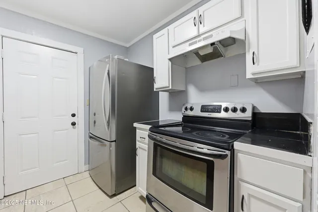 a kitchen with stainless steel appliances wooden cabinets and a stove top oven