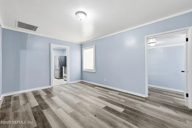 a view of a room with wooden floor and a bathroom