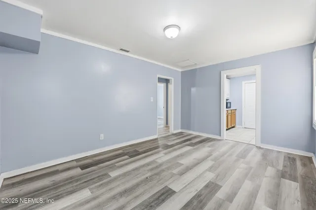 a view of empty room with wooden floor