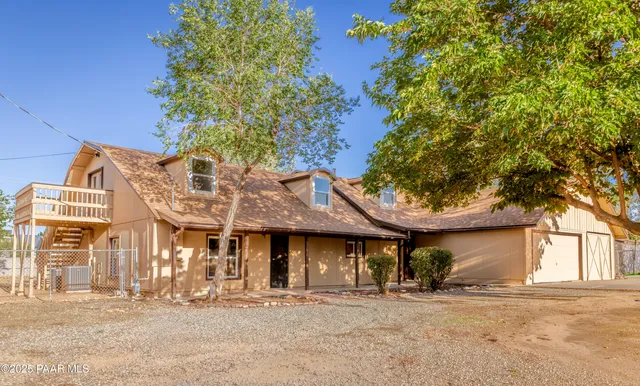a front view of a building with large trees