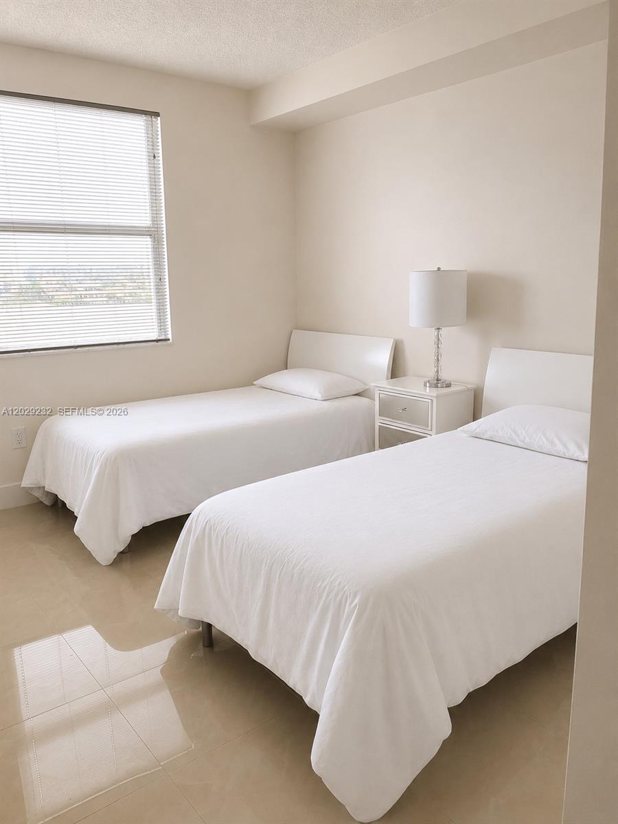 17100 North Bay Road, Unit 1605 Sunny Isles Beach, FL 33160 - Photo 16 of 52 a bedroom with two beds and a window