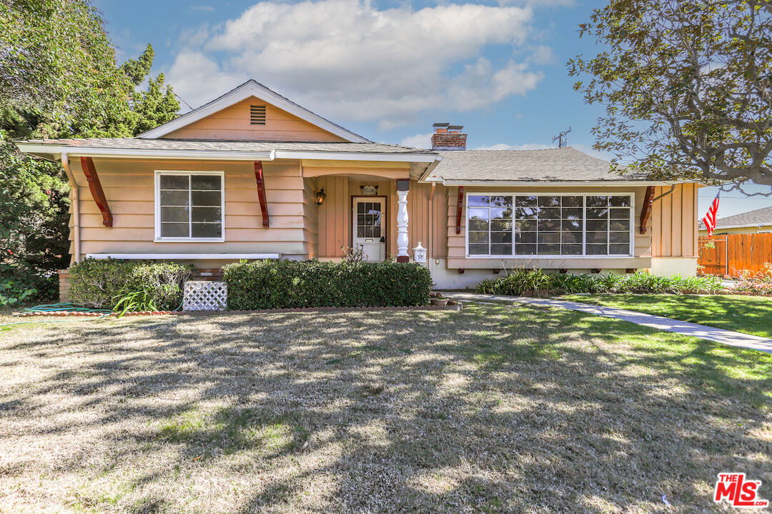 a front view of a house with a garden and plants