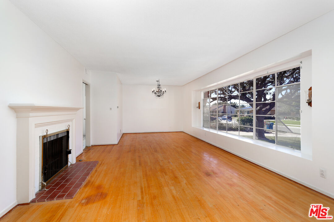 10310 Cullman Avenue Whittier, CA 90603 - Photo 11 of 30 a view of empty room with wooden floor and fireplace