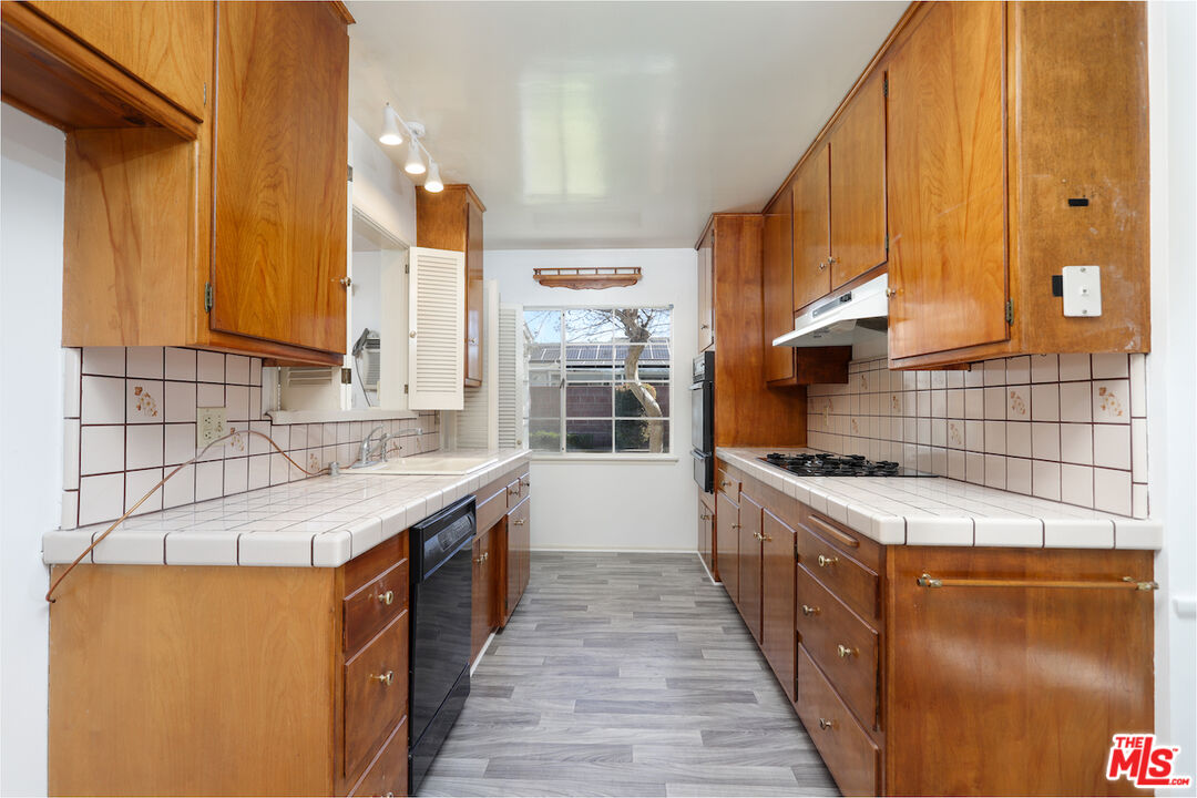 10310 Cullman Avenue Whittier, CA 90603 - Photo 12 of 30 a kitchen with stainless steel appliances granite countertop a stove a sink and a microwave