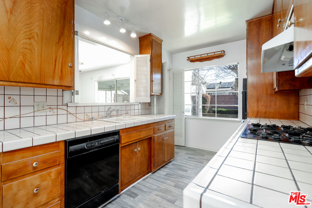 10310 Cullman Avenue Whittier, CA 90603 - Photo 13 of 30 a kitchen with stainless steel appliances granite countertop a stove a sink and a microwave