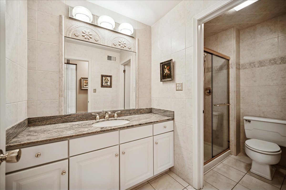 175 Lake Boulevard, Unit 301 Buffalo Grove, IL 60089 - Photo 12 of 15 a bathroom with a granite countertop sink mirror vanity and toilet