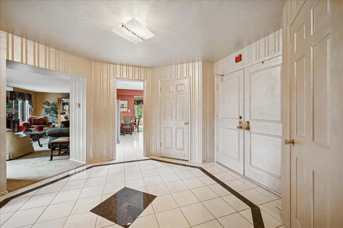 175 Lake Boulevard, Unit 301 Buffalo Grove, IL 60089 - Photo 2 of 15 a view of a hallway to a livingroom with wooden floor and a chandelier