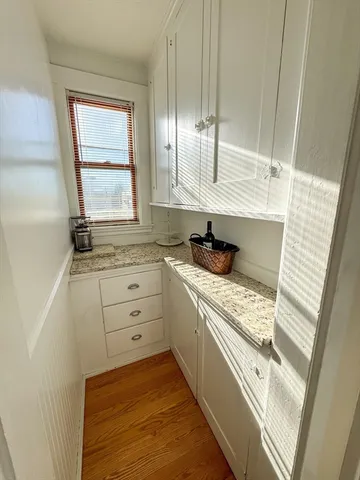 a kitchen with white cabinets and window