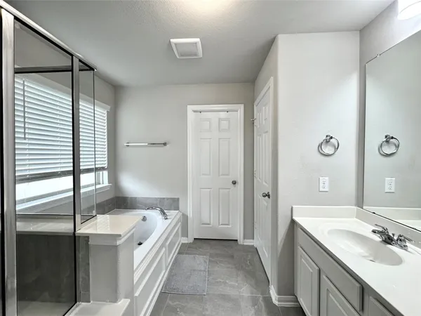 a spacious bathroom with a tub shower and sink