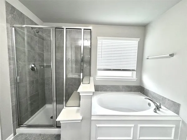 a bathroom with a tub sink and window