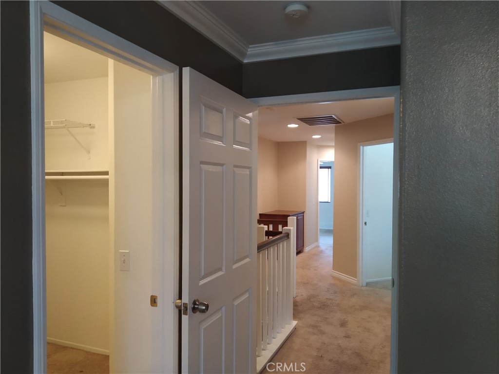 7715 Abbot Court Rancho Cucamonga, CA 91730 - Photo 15 of 22 a view of a hallway with a dining table and a refrigerator
