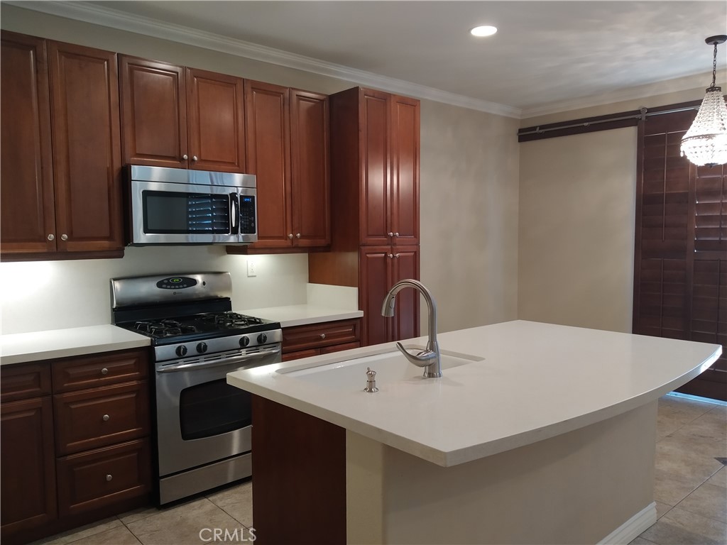 7715 Abbot Court Rancho Cucamonga, CA 91730 - Photo 9 of 22 a kitchen with a stove a microwave and wooden cabinets