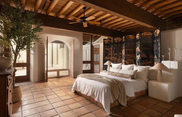 a view of a patio with table and chairs potted plants with floor to ceiling window and plants