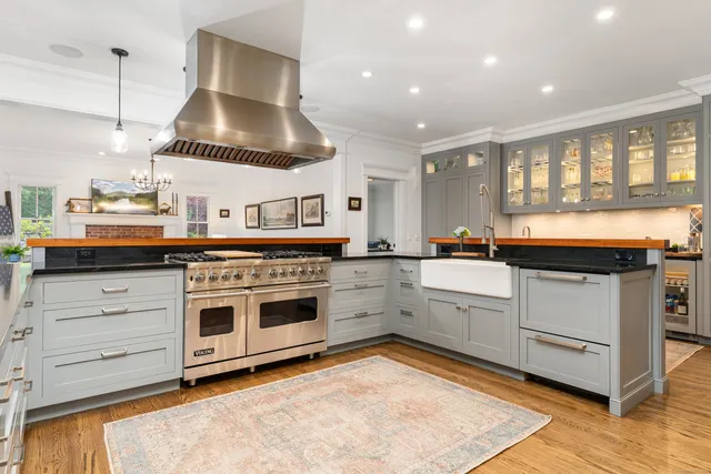 a kitchen with stainless steel appliances granite countertop a stove and a wooden floors