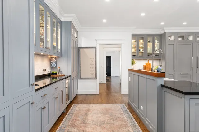 a kitchen with white cabinets and sink