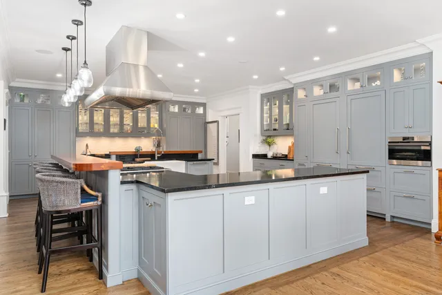 a kitchen with granite countertop a table chairs stove and wooden floor