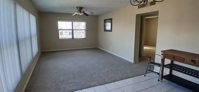 an empty room with windows and fan