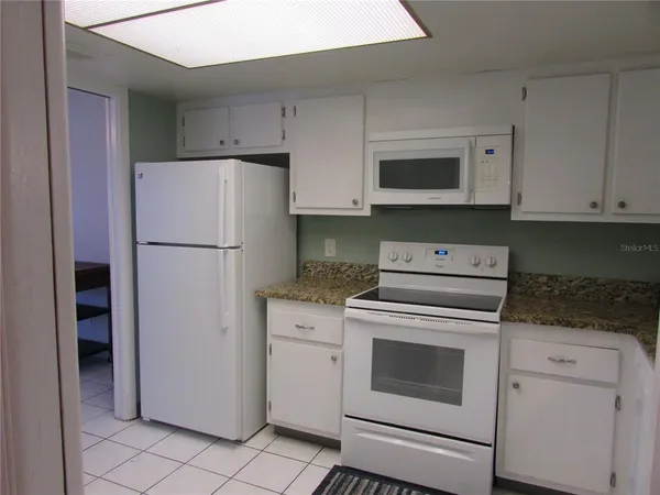 a kitchen with a stove top oven and refrigerator