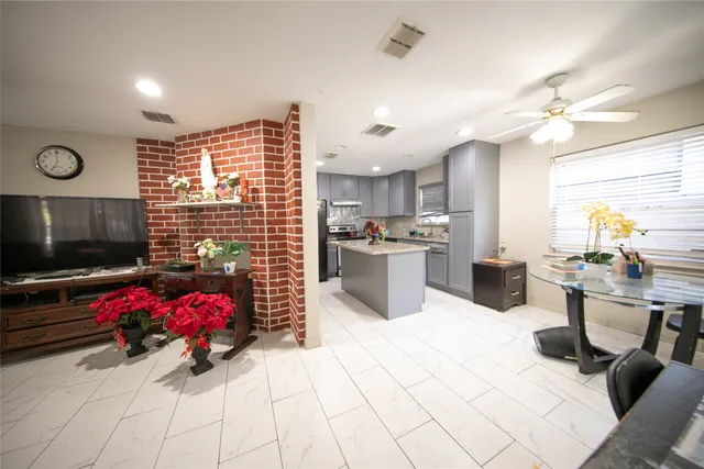 a living room with furniture a flat screen tv and kitchen view